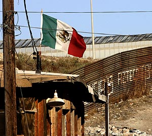 Una bandera mexicana ondea junto a un muro en Tijuana, en la frontera con EEUU. (Foto: AFP)