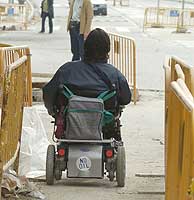 Una mujer en silla de ruedas se mueve entre las obras de la ciudad. (Foto: Jose Ayma)