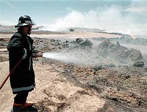 Un bombero apaga el lino que ardi en la localidad pacense de Berlanga en mayo de 1999. (Foto: Carlos Miralles)