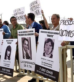 Familiares de vctimas del terrorismo muestran una pancarta de Zapatero, junto a fotografas de etarras. (EFE)