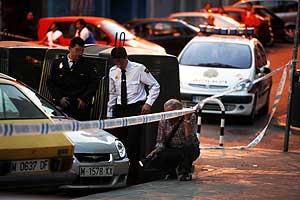 Tres policas buscan pruebas tras el tiroteo en Ciudad Lineal. (Foto: Antonio Heredia)