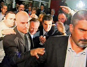 Josep Piqu, protegido por varios agentes de seguridad durante los altercados. (Foto: EFE)