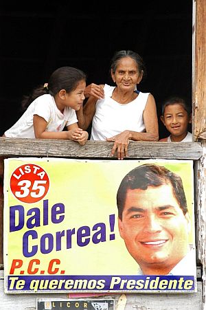 Varios ecuatorianos con un cartel de apoyo al candidato Rafael Correa