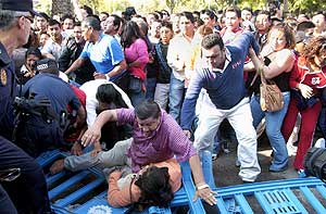 Varias personas caen al suelo arrastradas por otros votantes. (Foto: EFE)
