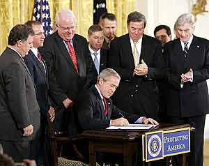 Bush estampa su firma rodeado de miembros de Congreso. (Foto: AP)