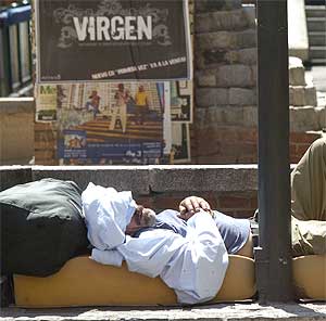 Un indigente duerme en una céntrica plaza de Madrid. (Foto: C. Miralles)