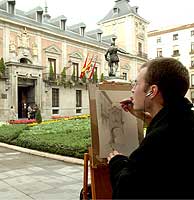 Un pintor en la Plaza de la Villa, pinta la fachada del Ayuntamiento de Madrid. (Foto:P. Toledo)