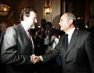Mariano Rajoy (izda.) y Manuel Chaves se saludan en los pasillos del Congreso. (Foto: EFE)