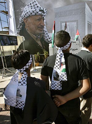 Dos niños, frente a un retrato de Yasir Arafat, durante el acto por el segundo aniversario de su muerte. (Foto: AP)
