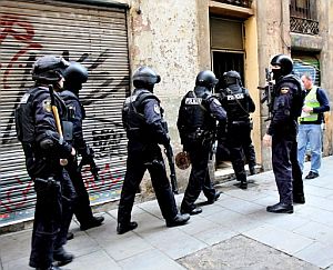 Agentes entran en un piso de la calle de Riera Baixa. (Foto: EFE)