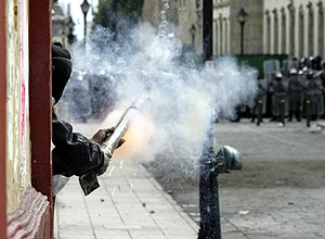 Un manifestante arroja cohetes a miembros de la polica. (Foto: REUTERS)