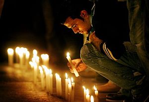 Un hombre enciende una vela por Gemayel en la escena del crimen. (Foto: AP)