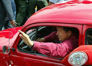 Hugo Chávez llega a su centro de votación al volante de un 'escarabajo' rojo. (Foto: AFP)