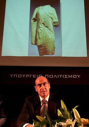 El ministro griego de Cultura, bajo la foto de una de las piezas. (Foto: EFE)