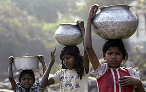 Tres nias transportando agua en la zona de Patna, en la India. (Foto: REUTERS)