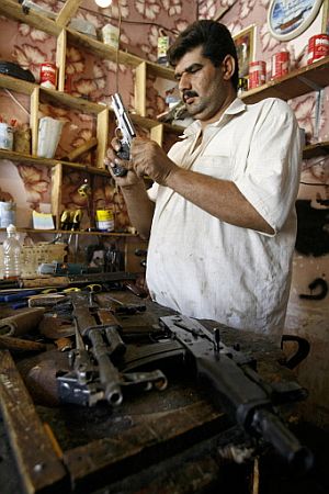 Un hombre comprueba sus armas en una tienda de Nayaf. (Foto: AFP)