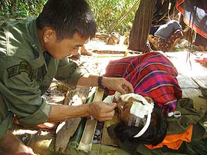 Un mdico atendiendo a una mujer herida por una mina terrestre colocada por el ejrcito birmano. (Foto: EFE)