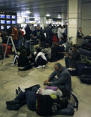 Pasajeros esperan dentro de la terminal del aeropuerto de Barajas. (Foto: EFE)