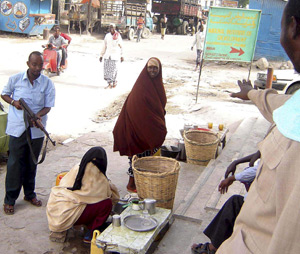 Un miliciano apunta a una vendedora en Mogadiscio. (Foto: EFE)
