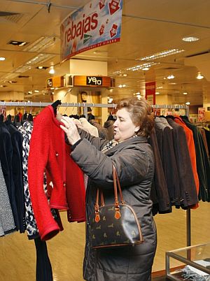 Una mujer examina una prenda en un centro comercial de Madrid. (Foto: EFE)