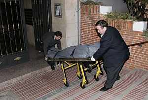 Operarios de los servicios funerarios trasladan el cadaver de una de las vctimas. (Foto: EFE)
