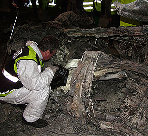 Un agente de la polica cientfica trabaja en la T-4, entre los restos del atentado. (Foto: Interior)