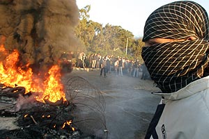 Uno de los huelguistas, ante una barricada de fuego. (Foto: REUTERS)