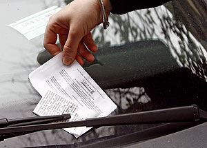 Un controlador pone una multa a un coche. (Foto: Alberto Cuellar)