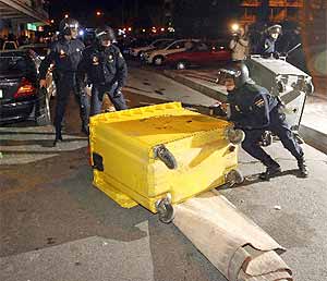 Policías retiran un contenedor que había sido volcado por jóvenes radicales. (Foto: EFE) MÁS IMÁGENES