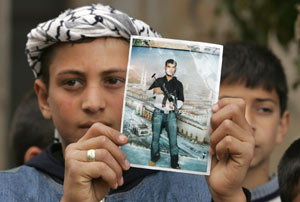 Un nio palestino muestra una foto del suicida. (Foto: REUTERS)