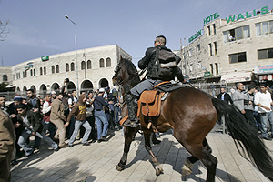Un polica montadao israel trata de dispersar a un grupo de palestinos. (Foto: