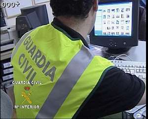 Un guardia civil rastrea un ordenador de los detenidos. (Foto: EFE)