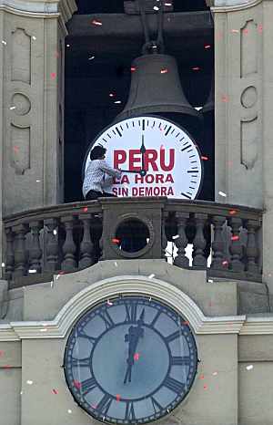 Un mimo realiza el ajuste simbólico de la hora en el campanario de la Catedral de Lima. (Foto: EFE)