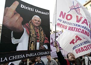 Manifestantes portan una parcarta de Benedicto XVI sobre la que reza: "Derechos humanos?". (Foto: REUTERS)