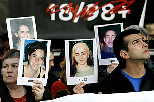 Varias personas muestran fotografías de presos durante la manifestación convocada por la Plataforma 18/98+. (Foto: EFE)
