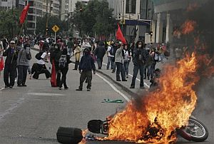 Una moto arde durante una protesta contra Bush en Bogotá. (Foto: AP)