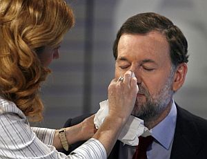 Una maquilladora repasa el rostro de Rajoy para la entrevista. (Foto: EFE)