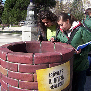 Dos chicas se asoman a un de los pozos que Intermn ha colocado en la Plaza de Espaa de Madrid. (Foto: Julia Girn)
