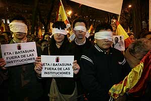 Manifestantes, con carteles en contra de Batasuna, ayer por la noche en la Castellana. (Foto: Diego Sinova)