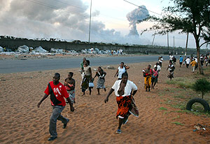 Varias personas corren alejndose de las explosiones. (Foto: EFE)