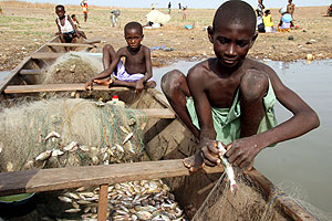 Nios ghaneses reparan redes de pescar en Yeji, una aldea de Ghana central. (Foto: EFE)