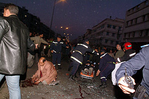 Mientras una persona herida es evacuada al hospital, la polica busca entre los escombros a uno de los terroristas. (Foto: EFE)