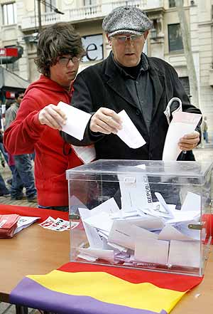 Dos ciudadanos depositian su voto durante el "referndum" simblico celebrado en Barcelona. (Foto: EFE)