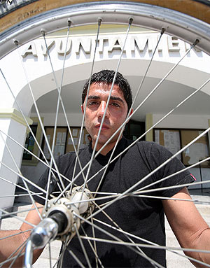 Miguel ngel Martn Perdiguero posa con una rueda de una bicicleta frente al Ayuntamiento de 'Sanse'. (Foto: S. Gonzlez)