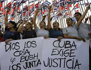 Varios cubanos muestran una pancarta en la manifestación en contra de la liberación de Posada Carriles. (Foto: AFP)