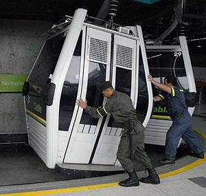 Un polica y un tcnico intentan controlar a mano las cabinas de Metrocable. (Foto: EFE)