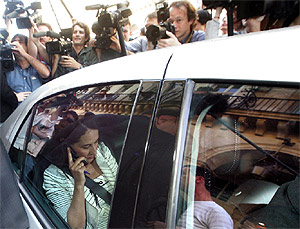 Asediada por fotógrafos, Royal habla por teléfono desde su coche este sábado, antes de debatir con Bayrou. (AFP)
