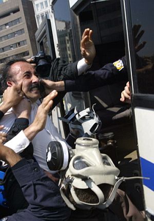 Varios policías tratan de introducir por la fuerza a un manifestante, agarrándose incluso a la cara del hombre, en un furgón. (Foto: AFP)