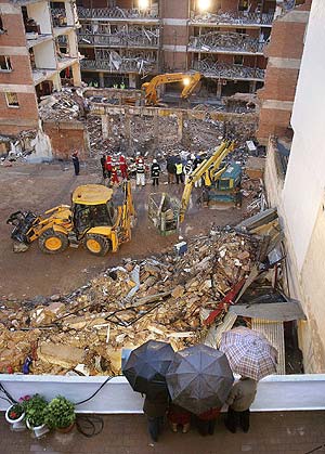 Unos vecinos contemplan las tareas de desescombro del edificio siniestrado. (Foto: REUTERS)