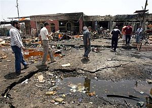 Unos hombres pasan junto al socavón provocado por el coche bomba de Bagdad. (Foto: AP)